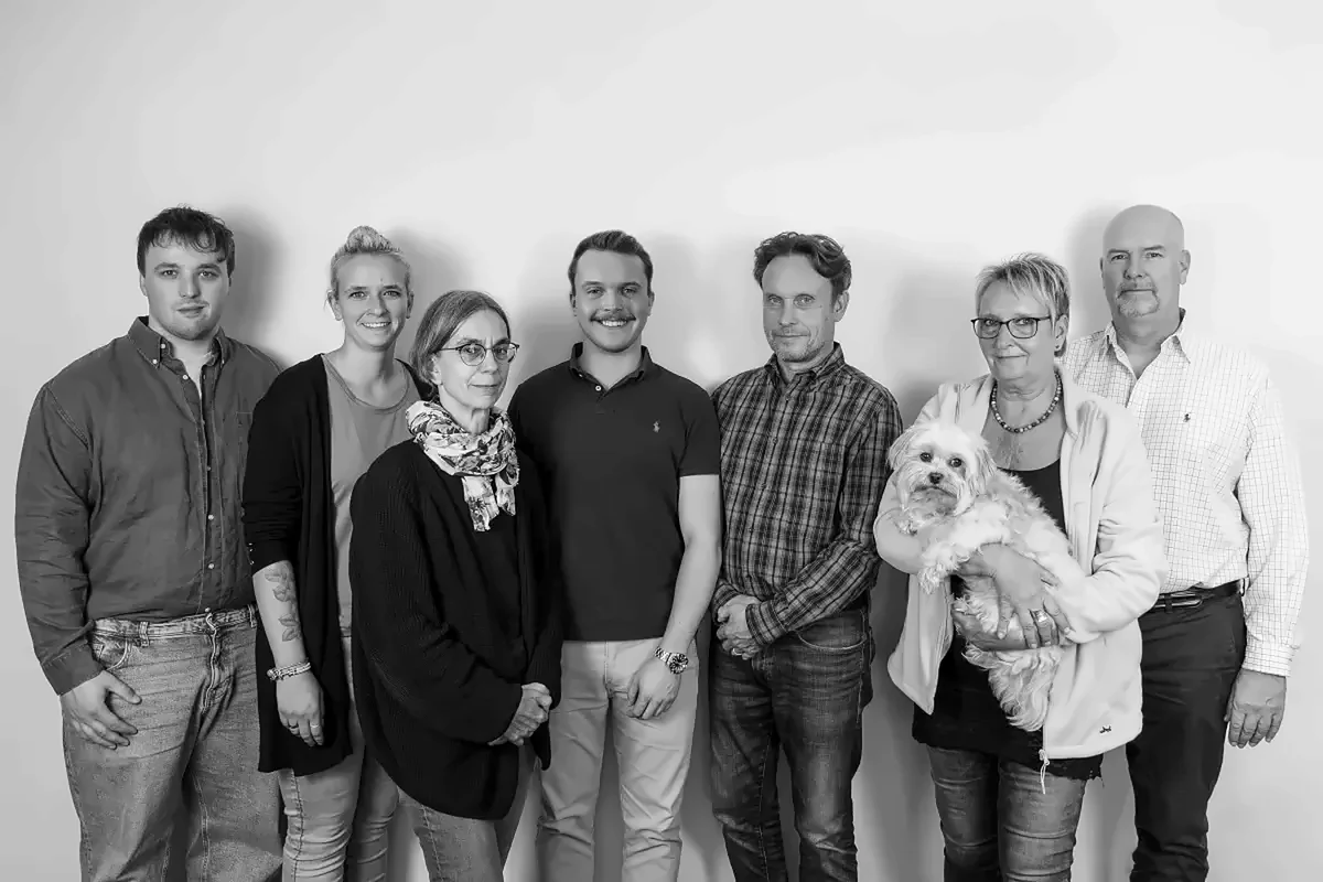 Das Team von Denker & Carstensen mit Bürohund Quando, Schwarzweißfoto
